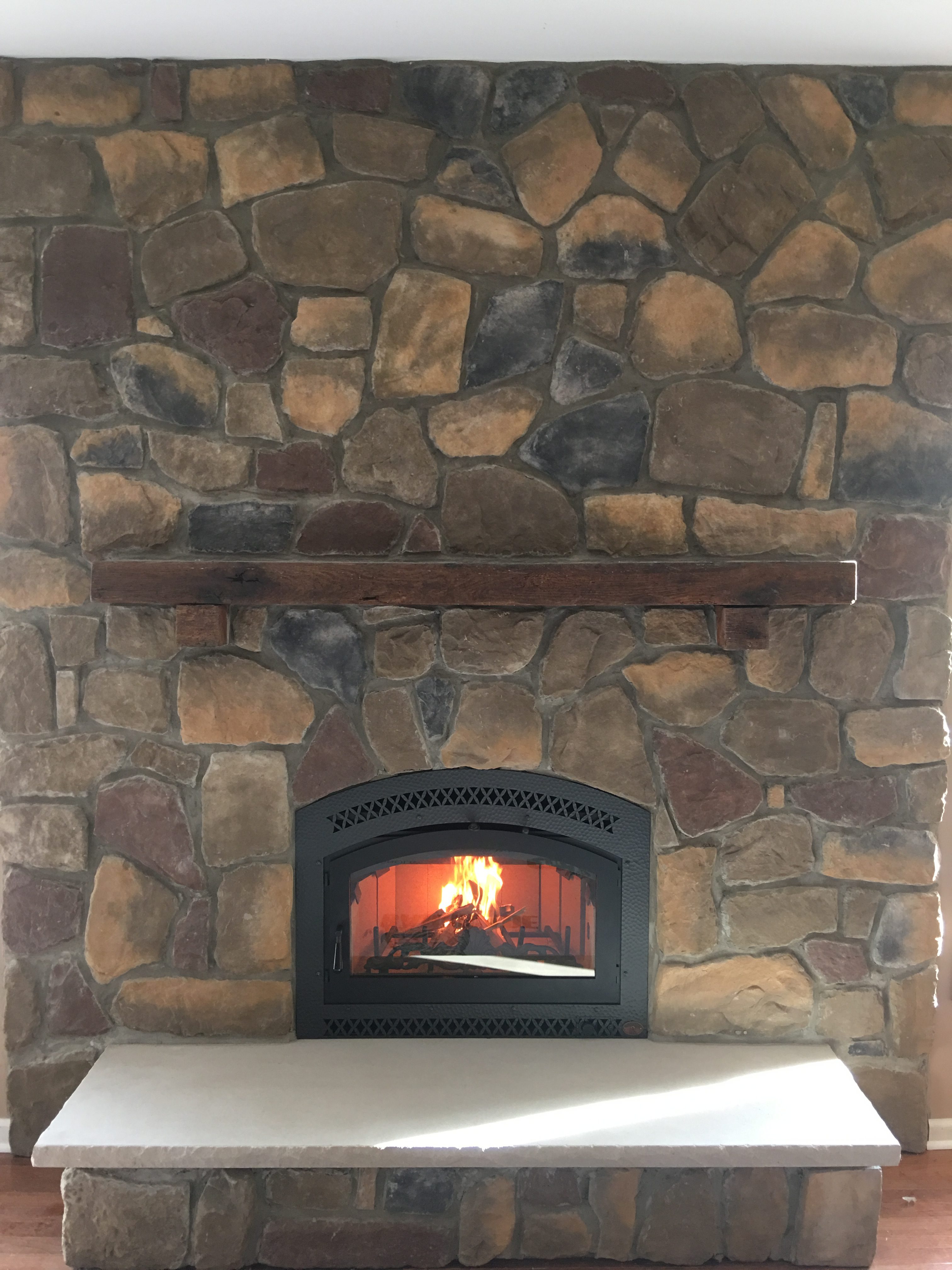 Image of a traditional 36 Elite wood fireplace by Fireplace X featuring rustic stonework facing and mantle.